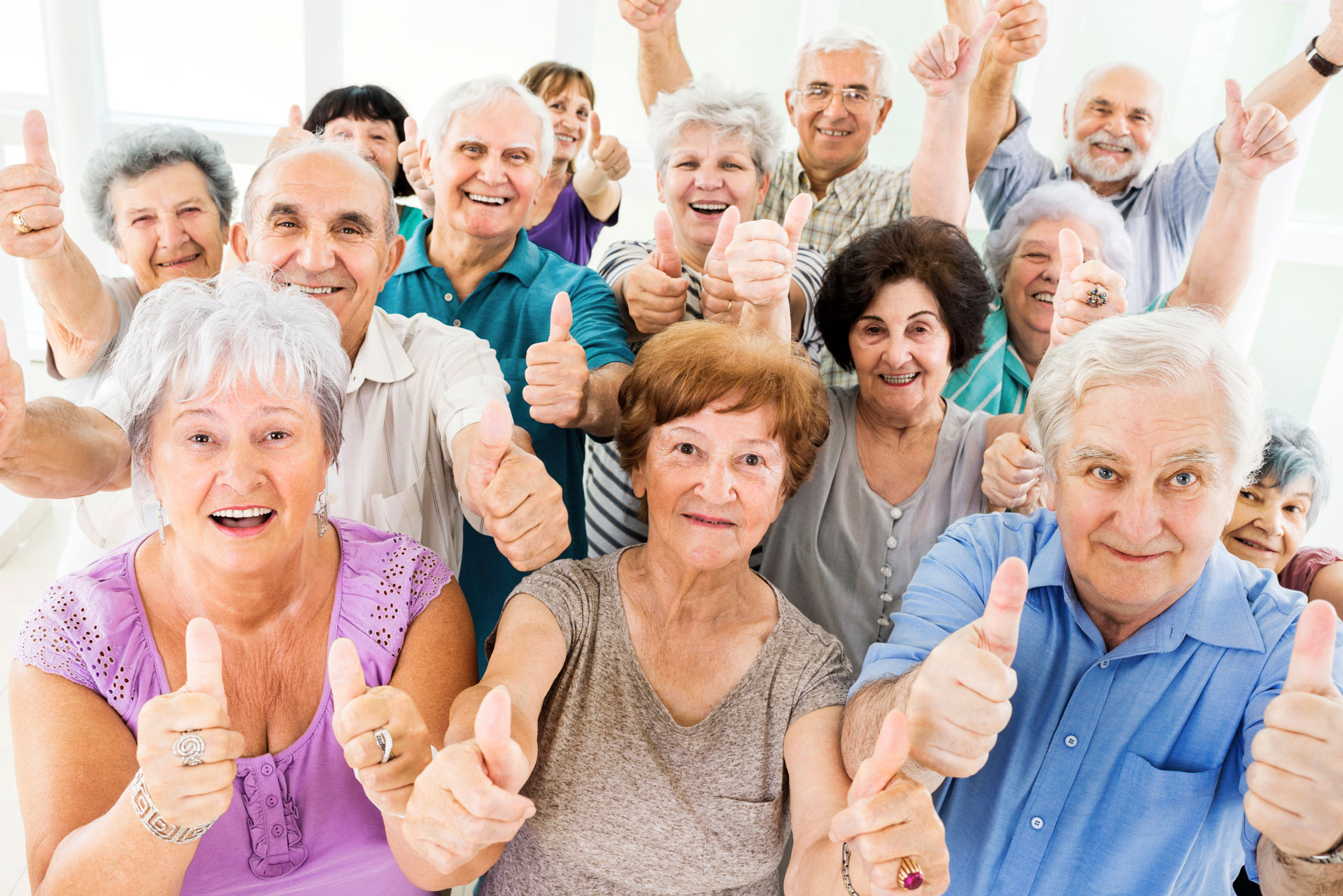 Happy senior citizens smiling thumbs up